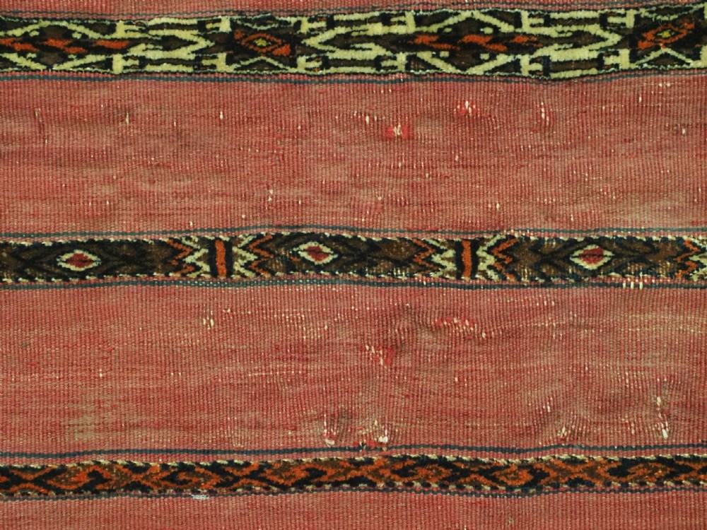 A horizontal rectangular antique Tekke Turkmen Kizil chuval face textile woven in red wool with dark geometric striped bands. View IX