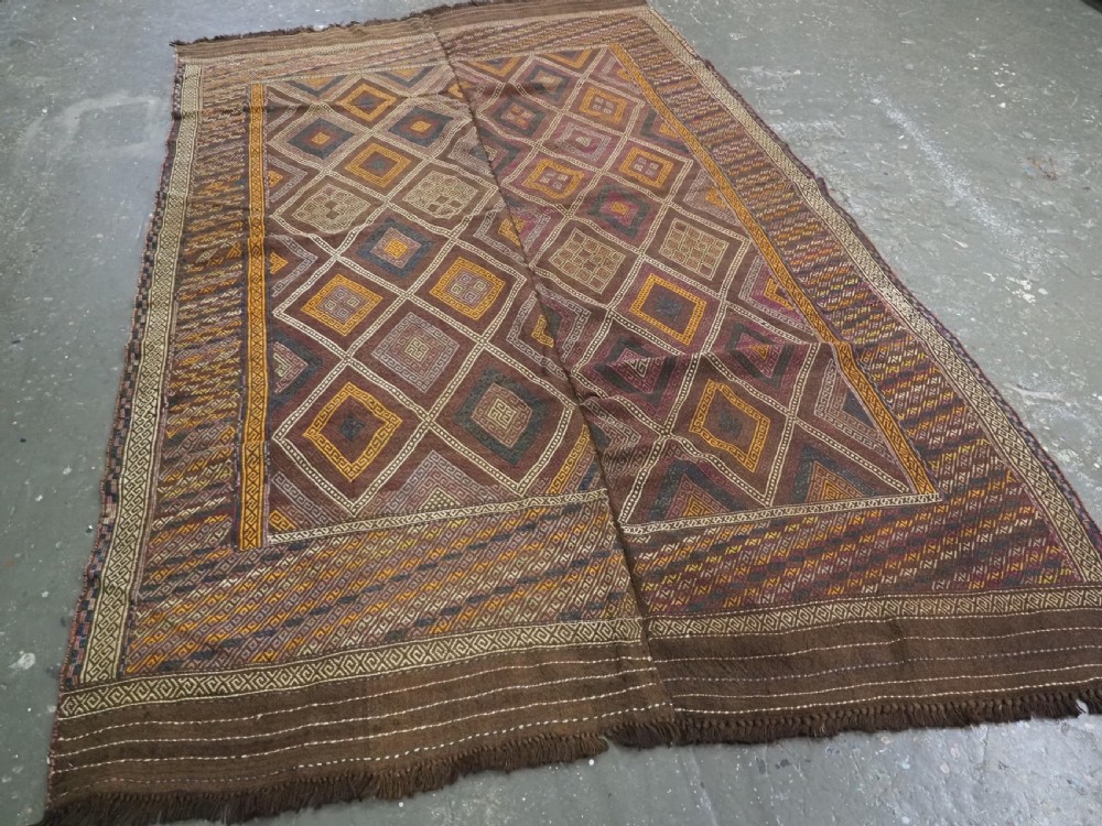 An antique Afghan flatweave wool kilim rug featuring a central brown field filled with geometric diamond motifs framed by patterned borders. View II