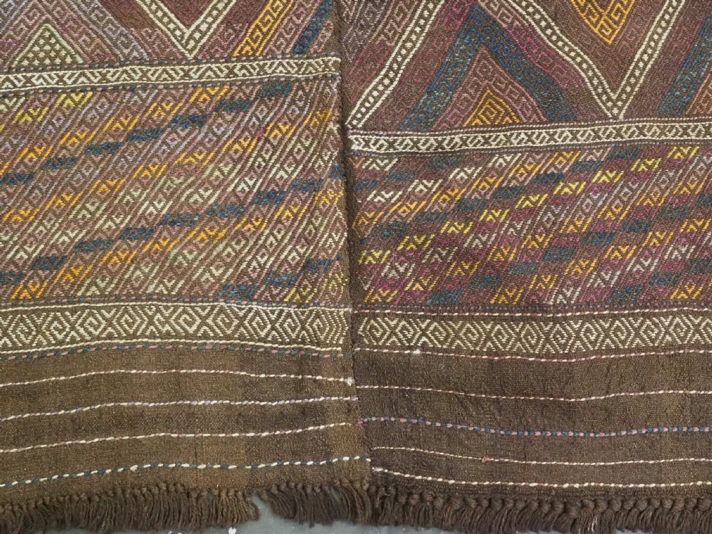 An antique Afghan flatweave wool kilim rug featuring a central brown field filled with geometric diamond motifs framed by patterned borders. View XI