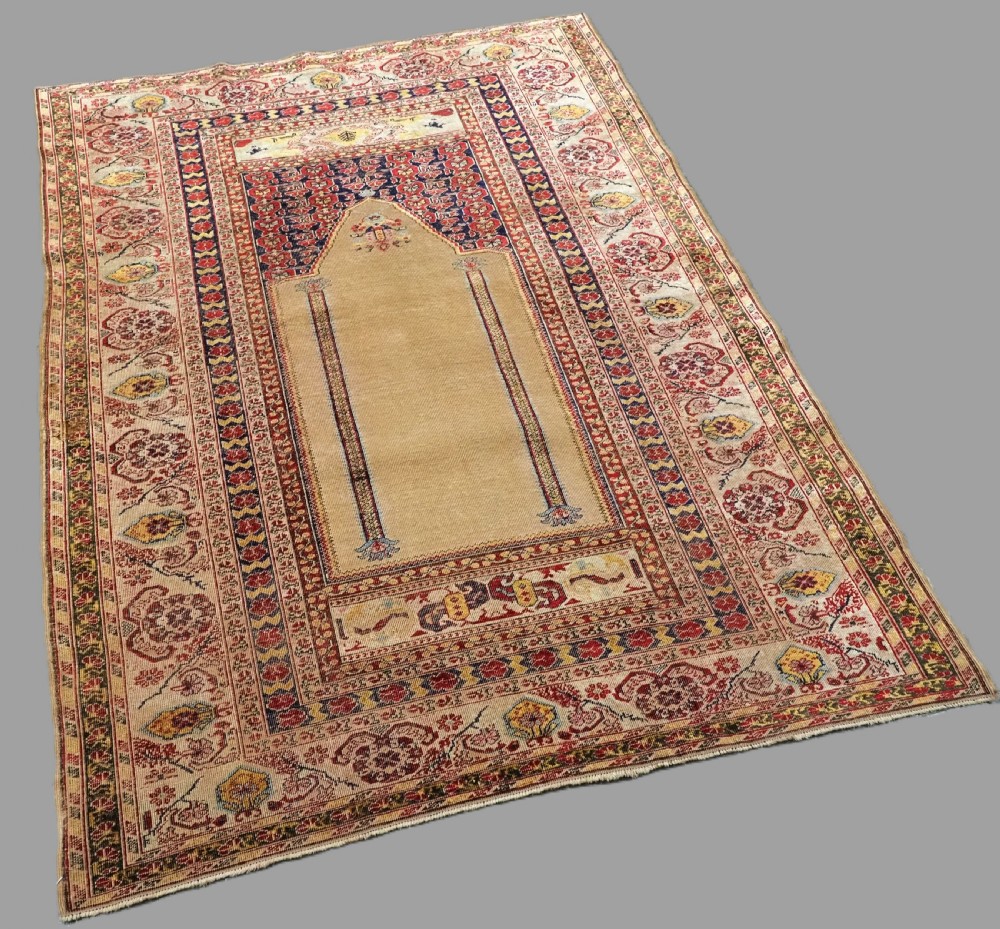 An antique late 19th-century Turkish Kayseri silk prayer rug featuring a central beige mihrab niche surrounded by geometric red and navy borders. View II