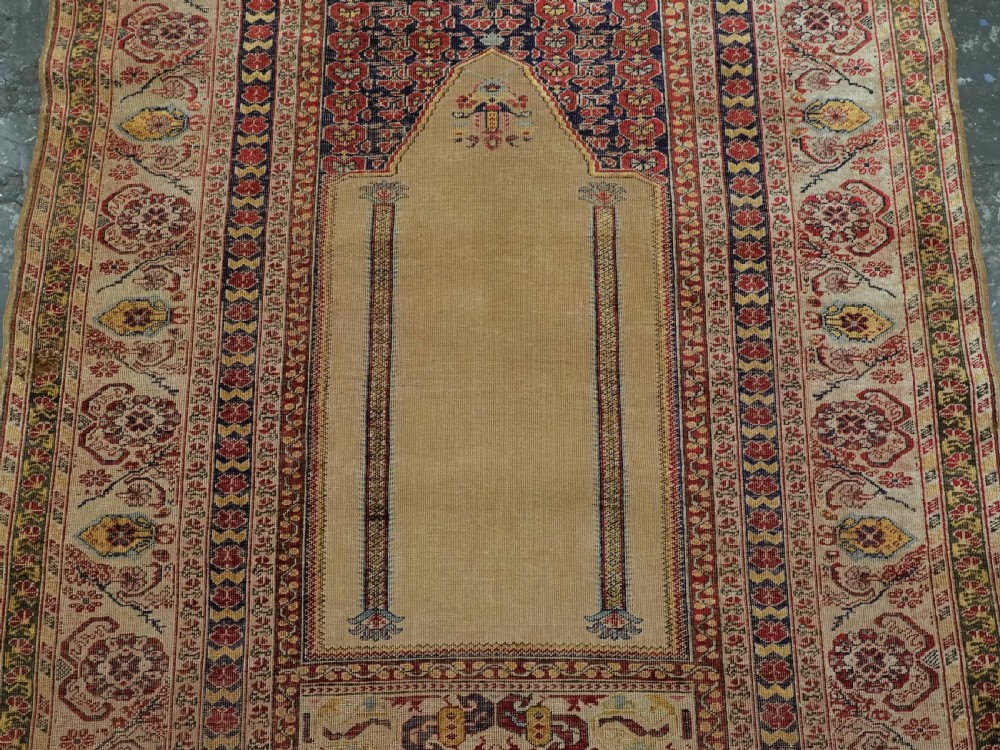 An antique late 19th-century Turkish Kayseri silk prayer rug featuring a central beige mihrab niche surrounded by geometric red and navy borders. View IV