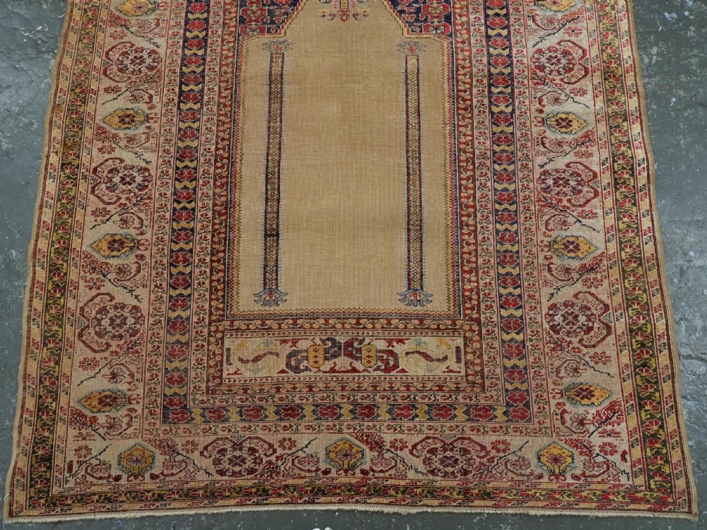 An antique late 19th-century Turkish Kayseri silk prayer rug featuring a central beige mihrab niche surrounded by geometric red and navy borders. View V