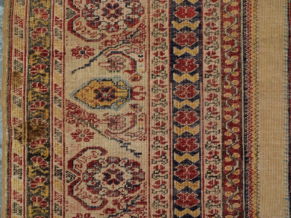 An antique late 19th-century Turkish Kayseri silk prayer rug featuring a central beige mihrab niche surrounded by geometric red and navy borders. View VII