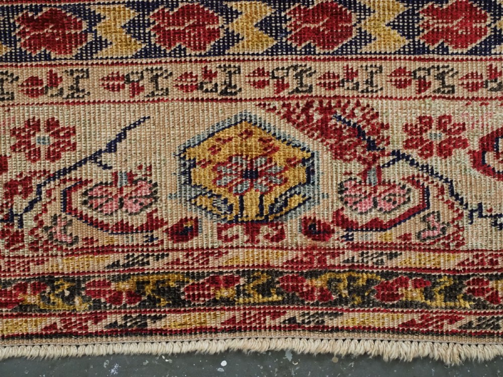 An antique late 19th-century Turkish Kayseri silk prayer rug featuring a central beige mihrab niche surrounded by geometric red and navy borders. View XV
