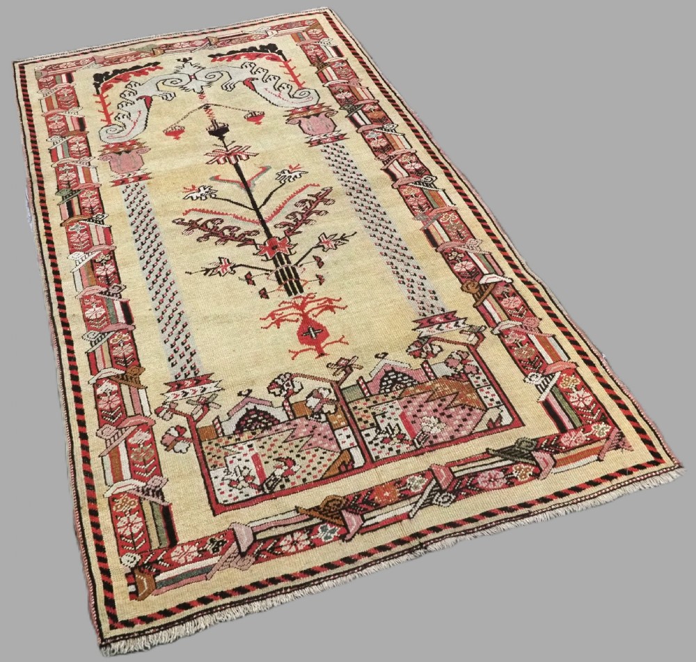 An antique Turkish Kirsehir wool prayer rug featuring a cream central field with a pointed mihrab niche, central tree of life motif, and geometric floral borders in muted red, pink, and green tones. View II