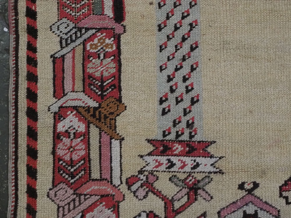 An antique Turkish Kirsehir wool prayer rug featuring a cream central field with a pointed mihrab niche, central tree of life motif, and geometric floral borders in muted red, pink, and green tones. View VII