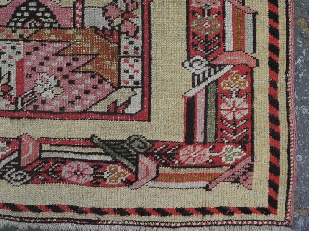 An antique Turkish Kirsehir wool prayer rug featuring a cream central field with a pointed mihrab niche, central tree of life motif, and geometric floral borders in muted red, pink, and green tones. View XI