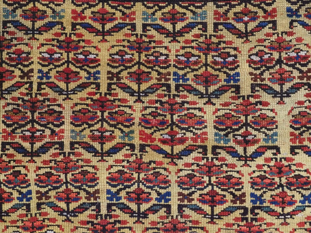 An antique hand-knotted Kurdish wool rug featuring a bright yellow central field with repeating red and blue shrub motifs enclosed within patterned borders. View VIII