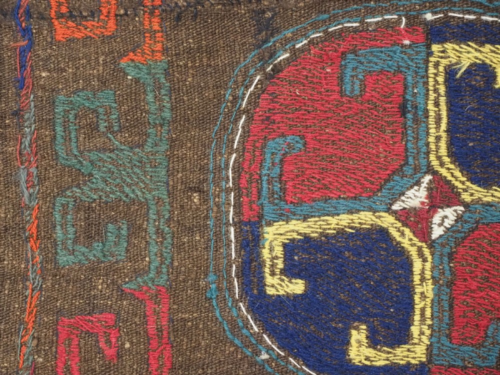 An antique brown camel hair flatweave kilim rug featuring fifteen circular embroidered medallions filled with colourful geometric motifs within a decorative hooked border. View XI