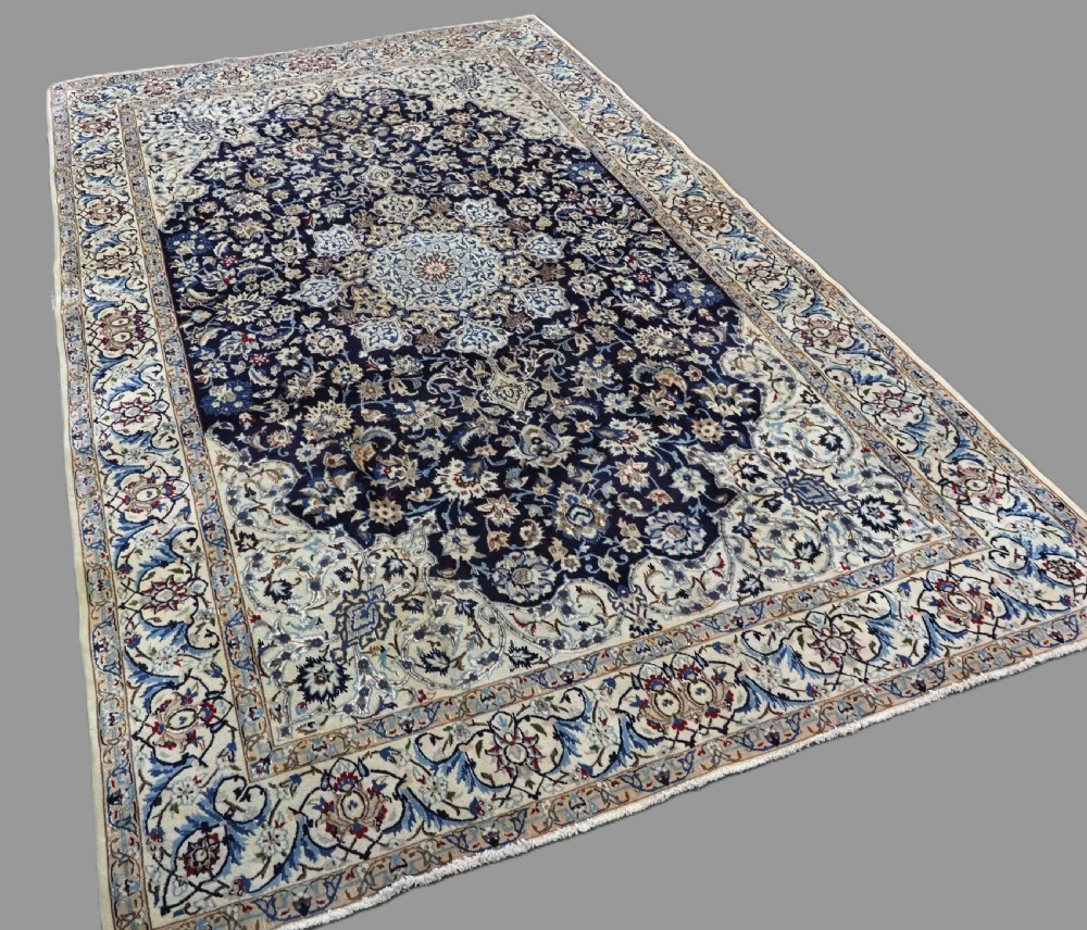 An antique hand-knotted Persian Nain carpet featuring an intricate central medallion in light blue and cream set against a deep navy blue field surrounded by elaborate floral borders. View II