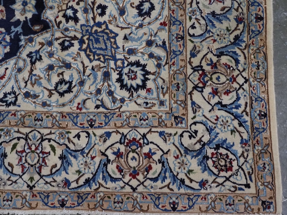 An antique hand-knotted Persian Nain carpet featuring an intricate central medallion in light blue and cream set against a deep navy blue field surrounded by elaborate floral borders. View XII