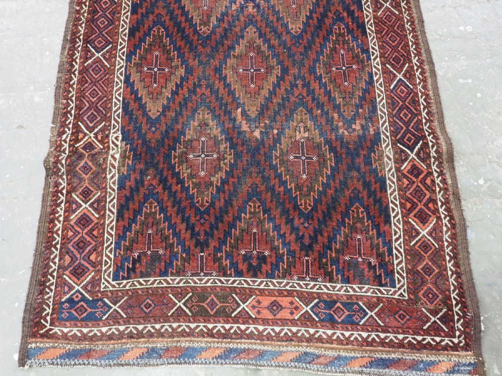 An antique hand-woven Arab Baluch runner rug featuring a dark navy blue and deep red geometric diamond lattice pattern with outer geometric borders. View V