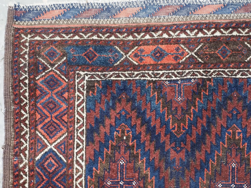 An antique hand-woven Arab Baluch runner rug featuring a dark navy blue and deep red geometric diamond lattice pattern with outer geometric borders. View VI