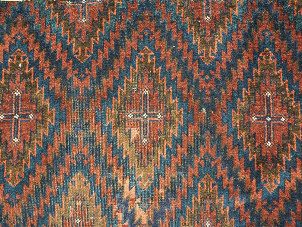 An antique hand-woven Arab Baluch runner rug featuring a dark navy blue and deep red geometric diamond lattice pattern with outer geometric borders. View VIII