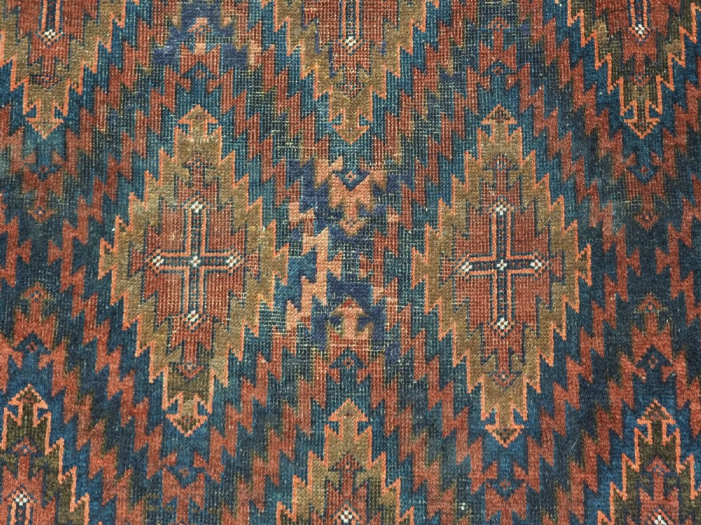 An antique hand-woven Arab Baluch runner rug featuring a dark navy blue and deep red geometric diamond lattice pattern with outer geometric borders. View IX