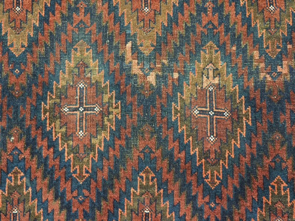 An antique hand-woven Arab Baluch runner rug featuring a dark navy blue and deep red geometric diamond lattice pattern with outer geometric borders. View X