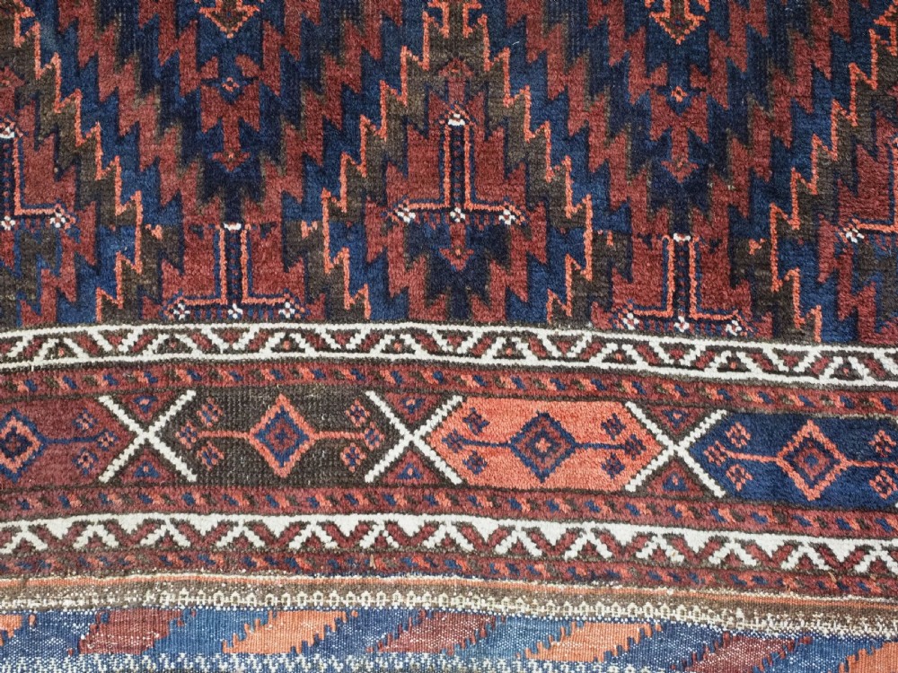 An antique hand-woven Arab Baluch runner rug featuring a dark navy blue and deep red geometric diamond lattice pattern with outer geometric borders. View XI
