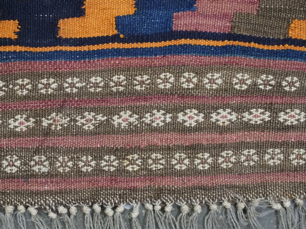 An antique flatwoven wool Baluch kilim with repeating geometric diamond patterns in blue, orange, brown, and purple shades, constructed in two joined panels. View XIV