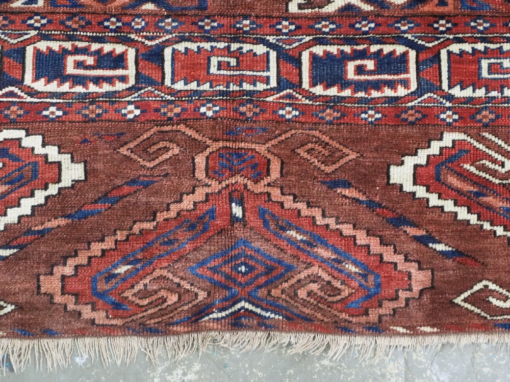 A long hand-knotted antique wool rug featuring a repeating dyrnak gul pattern in deep red, navy, and ivory tones surrounded by geometric borders. View XIII