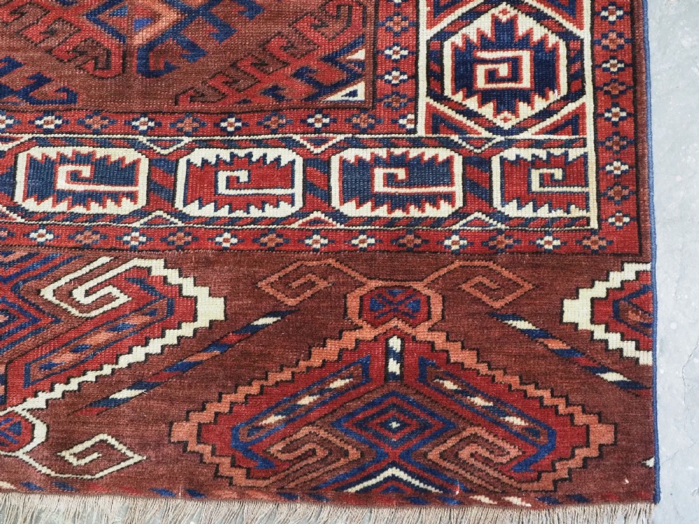 A long hand-knotted antique wool rug featuring a repeating dyrnak gul pattern in deep red, navy, and ivory tones surrounded by geometric borders. View XIV