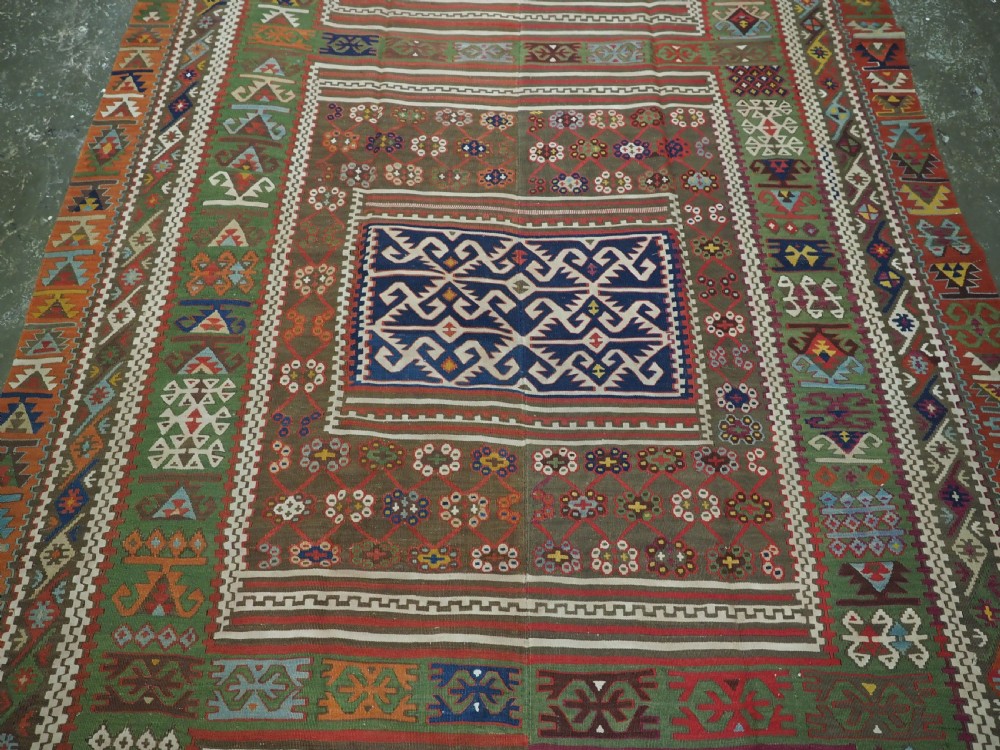 An antique Turkish Reyhanli flatweave kilim runner featuring multi-coloured geometric medallions joined along a central seam with a red border. View IV