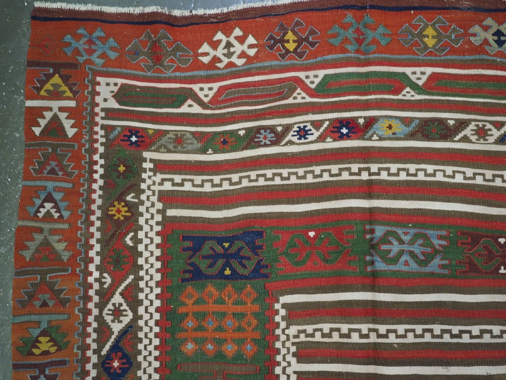 An antique Turkish Reyhanli flatweave kilim runner featuring multi-coloured geometric medallions joined along a central seam with a red border. View VI