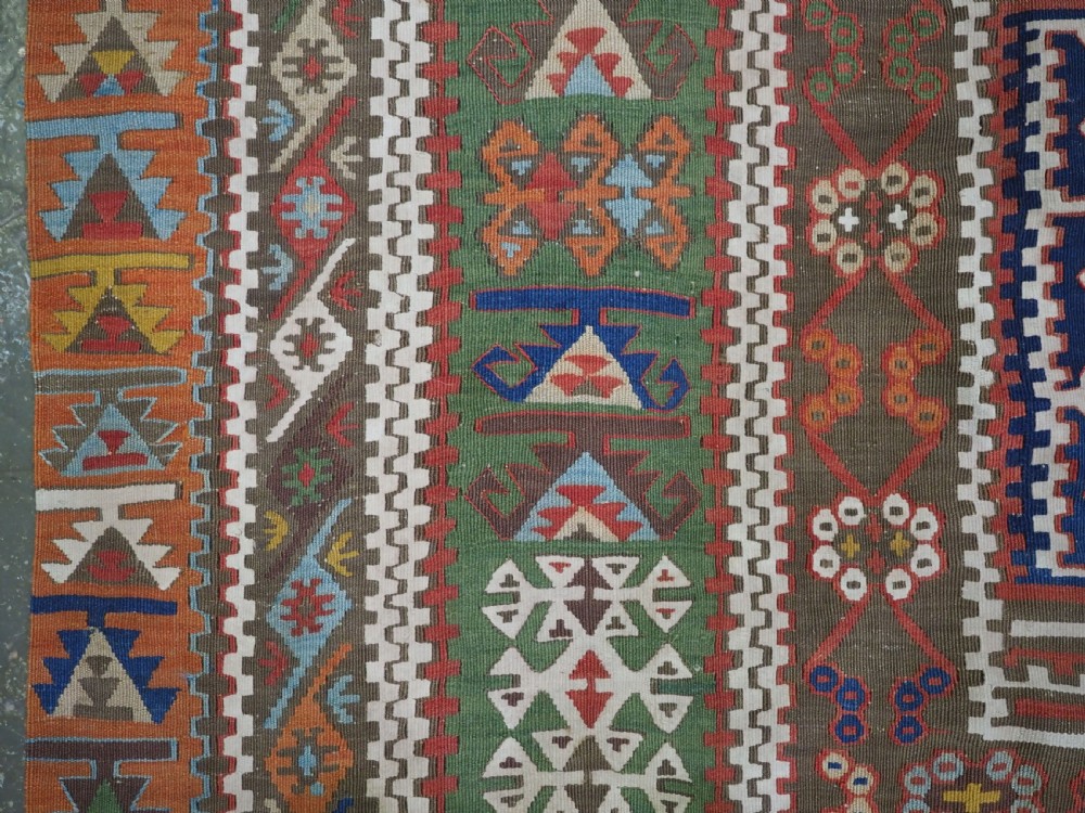 An antique Turkish Reyhanli flatweave kilim runner featuring multi-coloured geometric medallions joined along a central seam with a red border. View VII