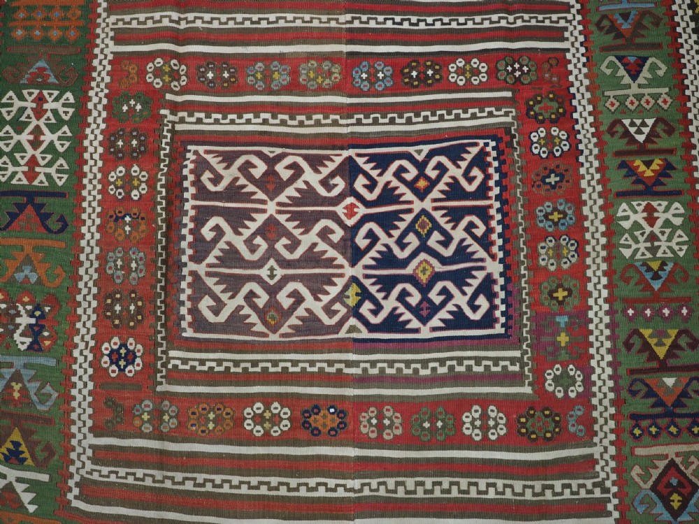 An antique Turkish Reyhanli flatweave kilim runner featuring multi-coloured geometric medallions joined along a central seam with a red border. View VIII