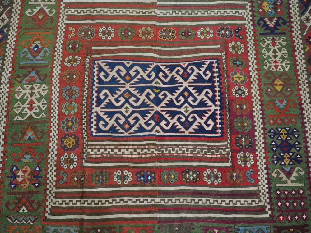 An antique Turkish Reyhanli flatweave kilim runner featuring multi-coloured geometric medallions joined along a central seam with a red border. View XI