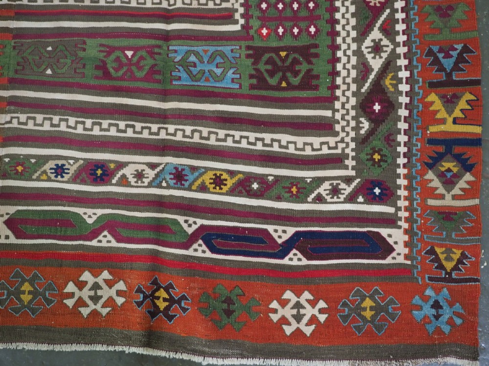 An antique Turkish Reyhanli flatweave kilim runner featuring multi-coloured geometric medallions joined along a central seam with a red border. View XII