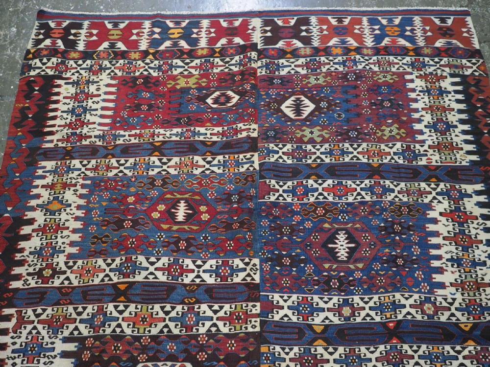 An antique Turkish Bergama Karakecili flatweave kilim rug featuring bold geometric diamond motifs woven in two connected vertical sections in shades of red, navy blue, and cream. View III