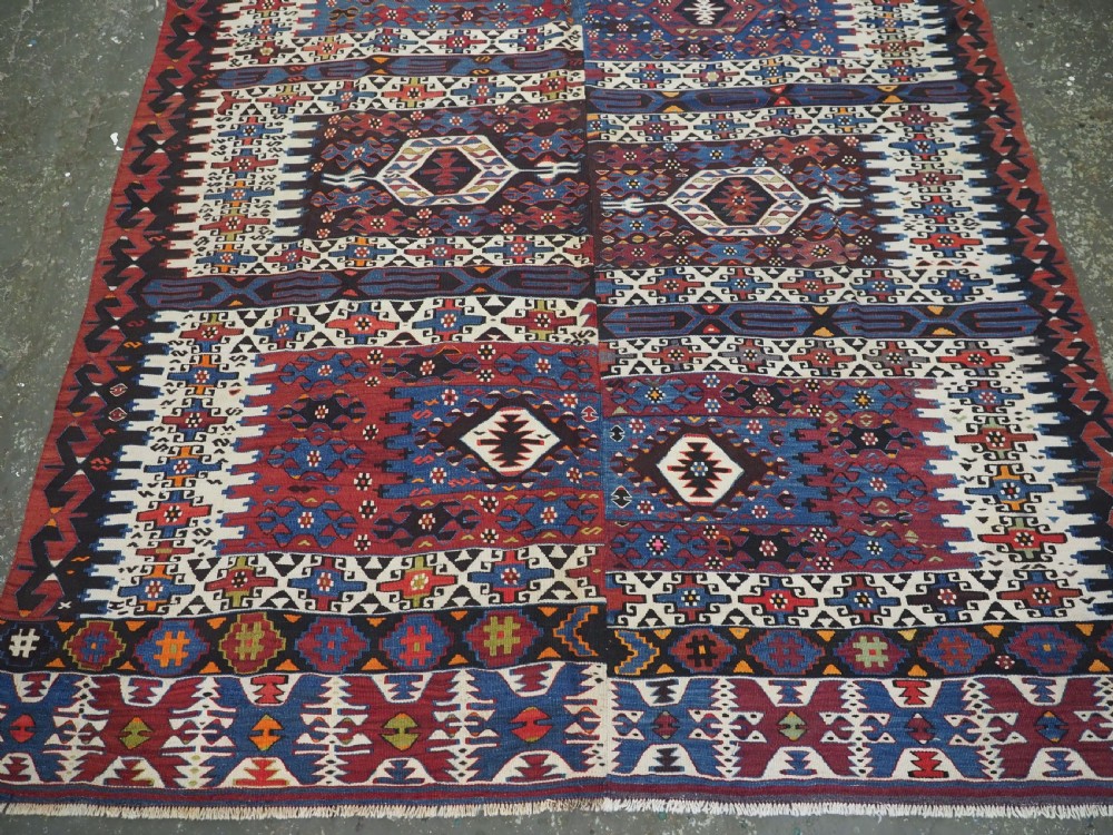 An antique Turkish Bergama Karakecili flatweave kilim rug featuring bold geometric diamond motifs woven in two connected vertical sections in shades of red, navy blue, and cream. View VI
