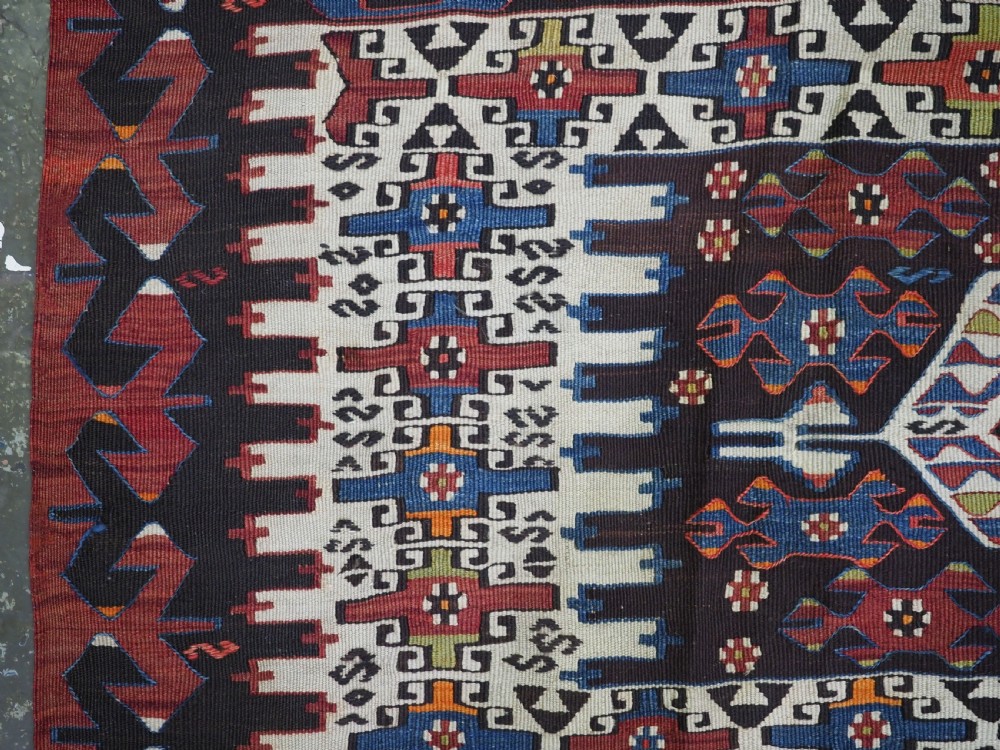 An antique Turkish Bergama Karakecili flatweave kilim rug featuring bold geometric diamond motifs woven in two connected vertical sections in shades of red, navy blue, and cream. View VII