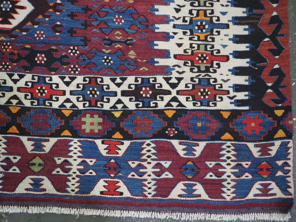An antique Turkish Bergama Karakecili flatweave kilim rug featuring bold geometric diamond motifs woven in two connected vertical sections in shades of red, navy blue, and cream. View VIII