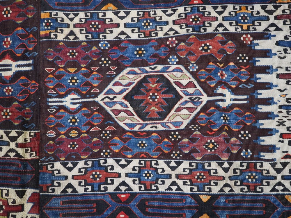 An antique Turkish Bergama Karakecili flatweave kilim rug featuring bold geometric diamond motifs woven in two connected vertical sections in shades of red, navy blue, and cream. View IX