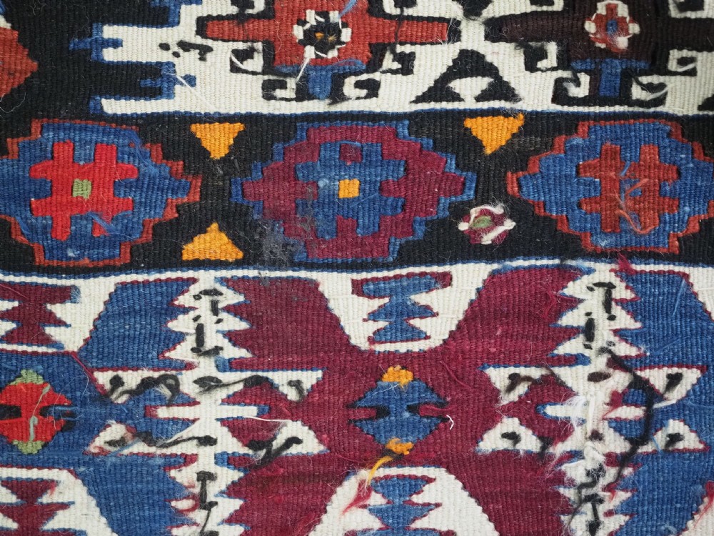 An antique Turkish Bergama Karakecili flatweave kilim rug featuring bold geometric diamond motifs woven in two connected vertical sections in shades of red, navy blue, and cream. View X