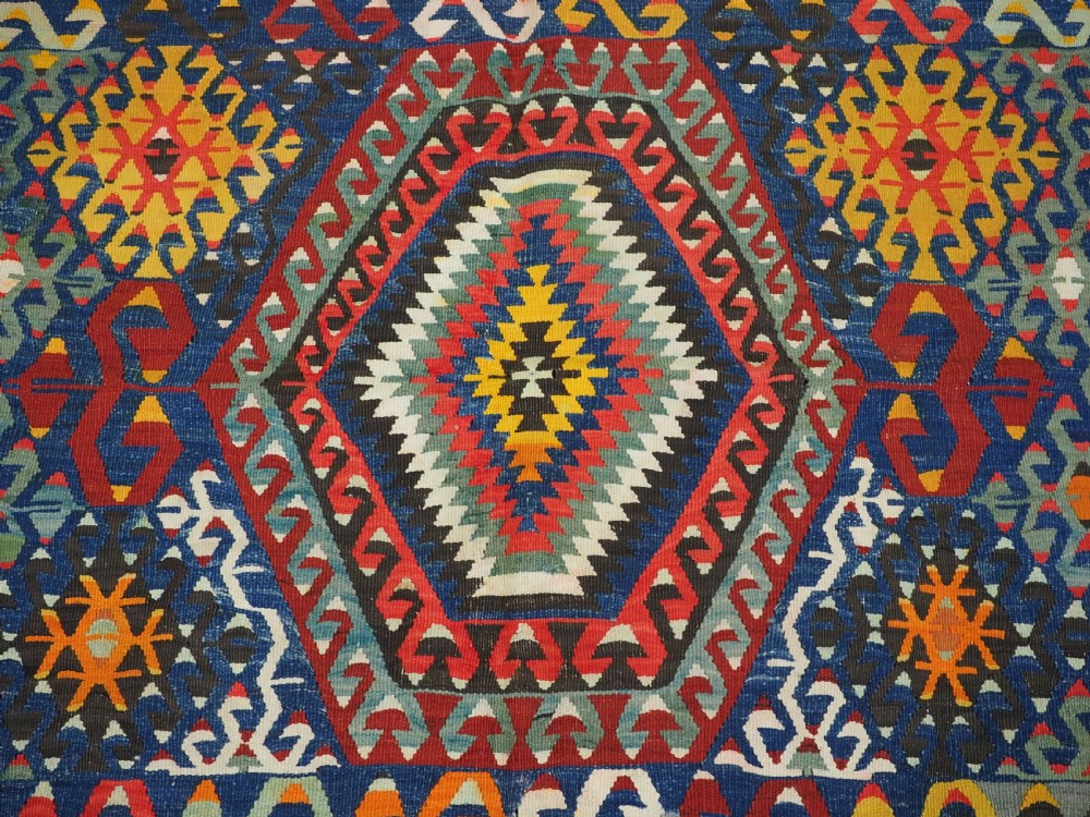 A handwoven Turkish Esme kilim rug displaying geometric diamond medallions in red, blue, yellow, and green wool. View XI
