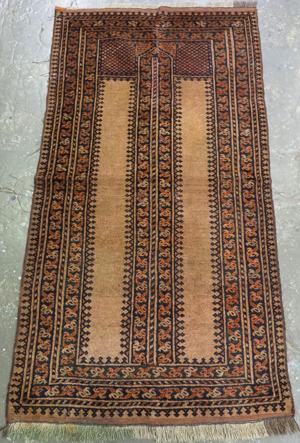 An antique hand-knotted Afghan Kizil Ayak wool prayer rug featuring a tan field, dark geometric borders, and a pointed mihrab motif.