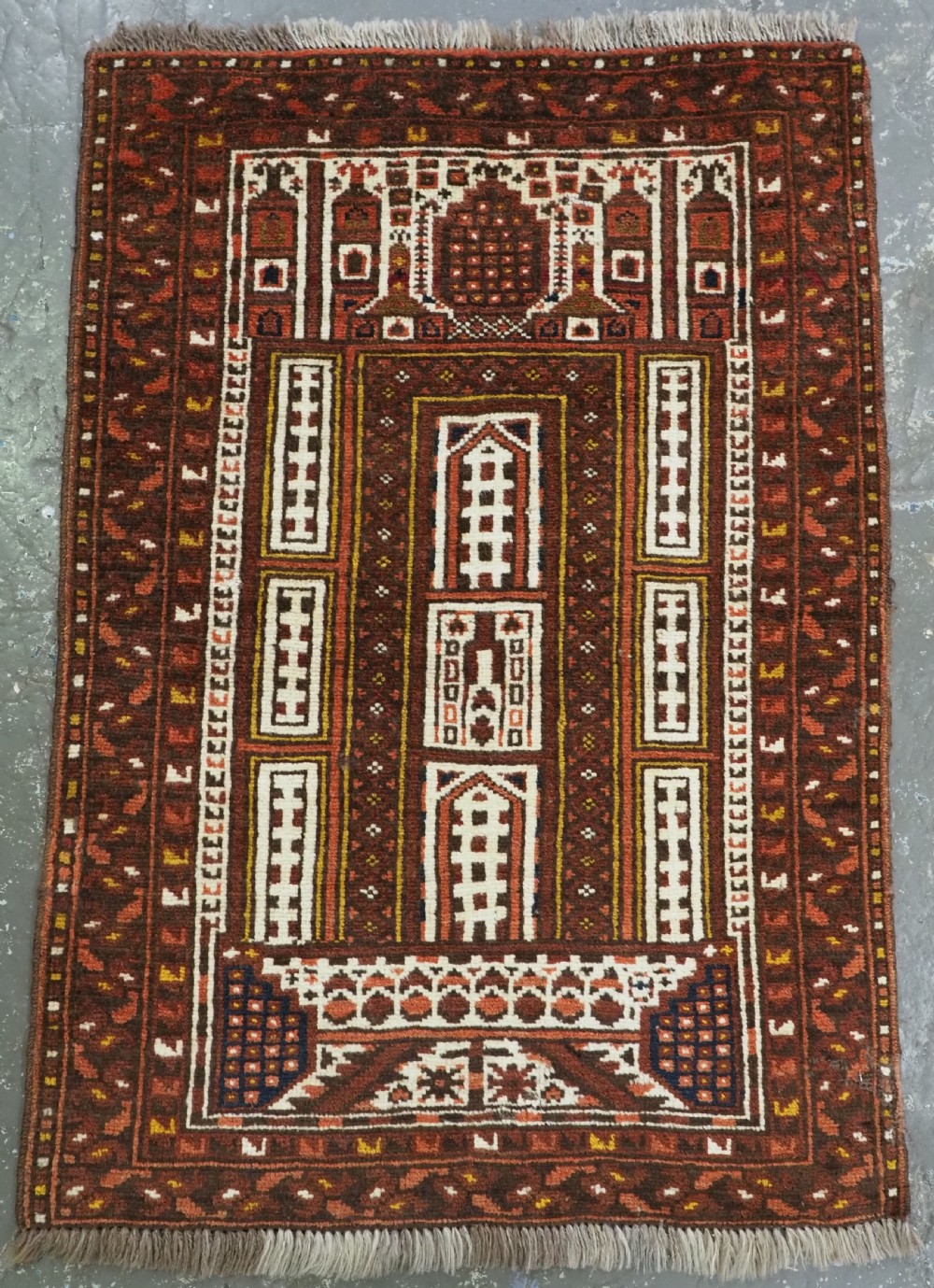 An antique hand-knotted Afghan Kizil Ayak wool prayer rug featuring geometric mosque architectural motifs in terracotta red, deep brown, cream, and mustard yellow.