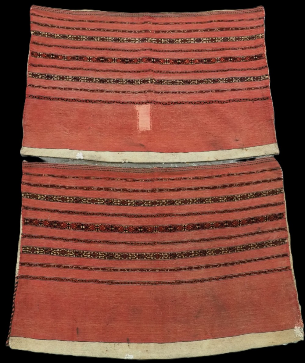 A pair of antique Tekke Turkmen woven wool Kizil cuval bags featuring horizontal red and patterned geometric stripes with cream selvedges.