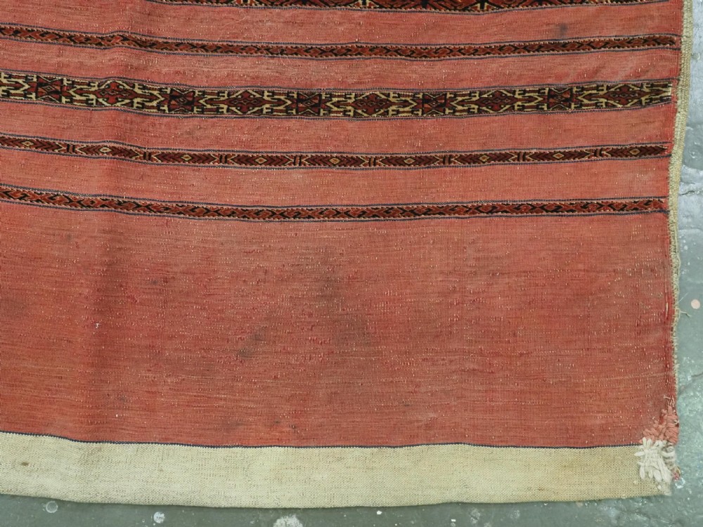A pair of antique Tekke Turkmen woven wool Kizil cuval bags featuring horizontal red and patterned geometric stripes with cream selvedges. View V