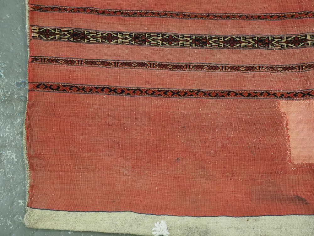 A pair of antique Tekke Turkmen woven wool Kizil cuval bags featuring horizontal red and patterned geometric stripes with cream selvedges. View IX