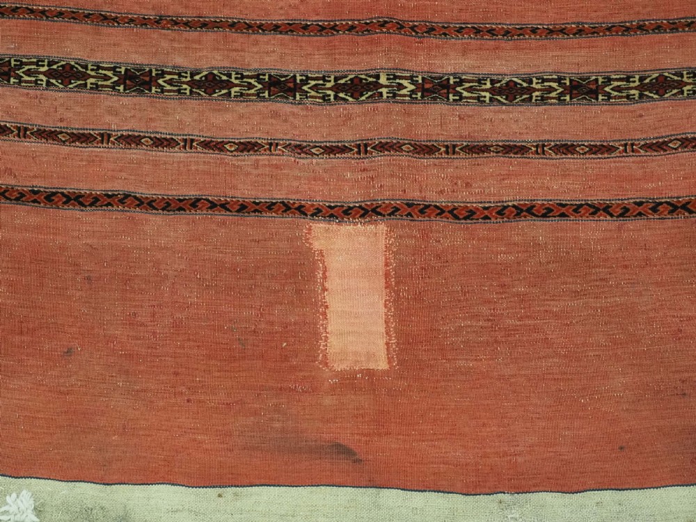 A pair of antique Tekke Turkmen woven wool Kizil cuval bags featuring horizontal red and patterned geometric stripes with cream selvedges. View X