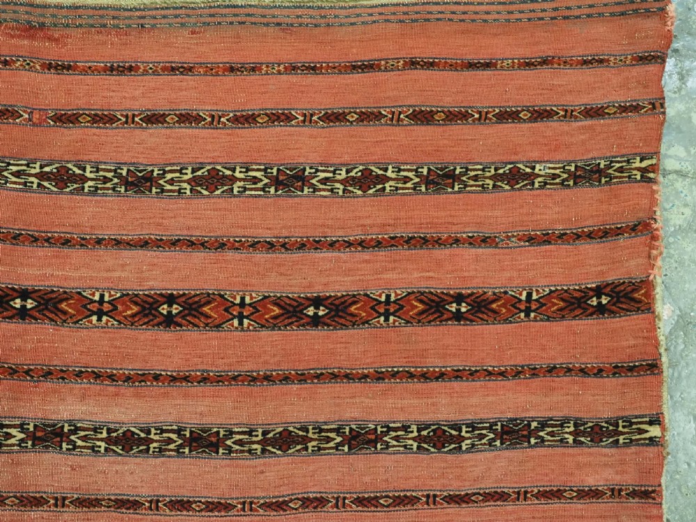 A pair of antique Tekke Turkmen woven wool Kizil cuval bags featuring horizontal red and patterned geometric stripes with cream selvedges. View XI