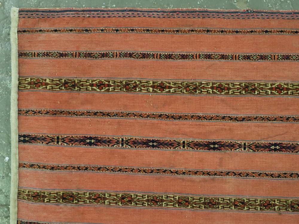 A pair of rectangular antique Turkmen Kizil chuval woven textiles in terracotta red with thin horizontal geometric bands and cream backing edges. View V