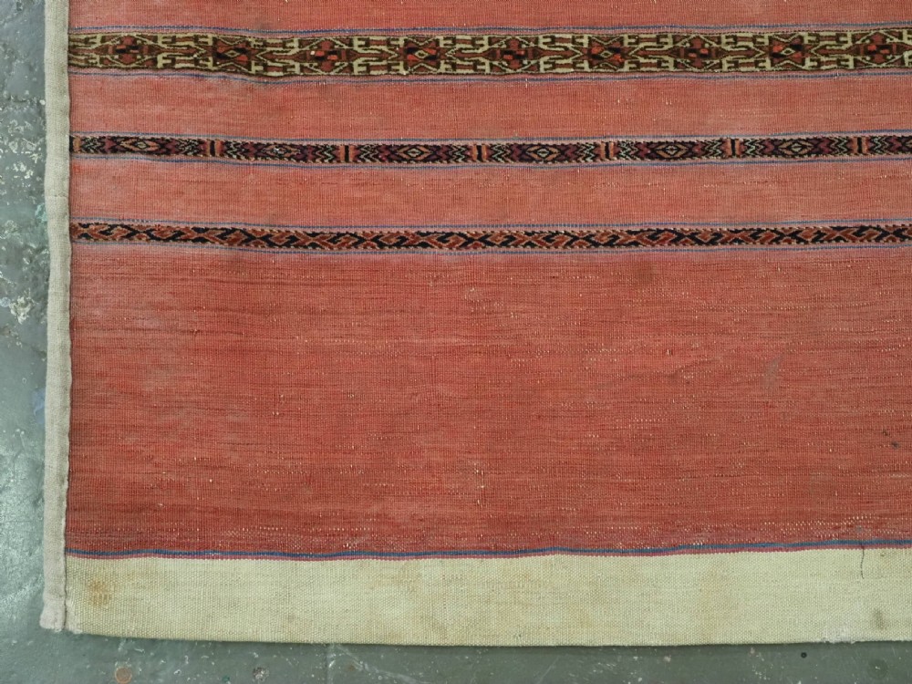 A pair of rectangular antique Turkmen Kizil chuval woven textiles in terracotta red with thin horizontal geometric bands and cream backing edges. View VI