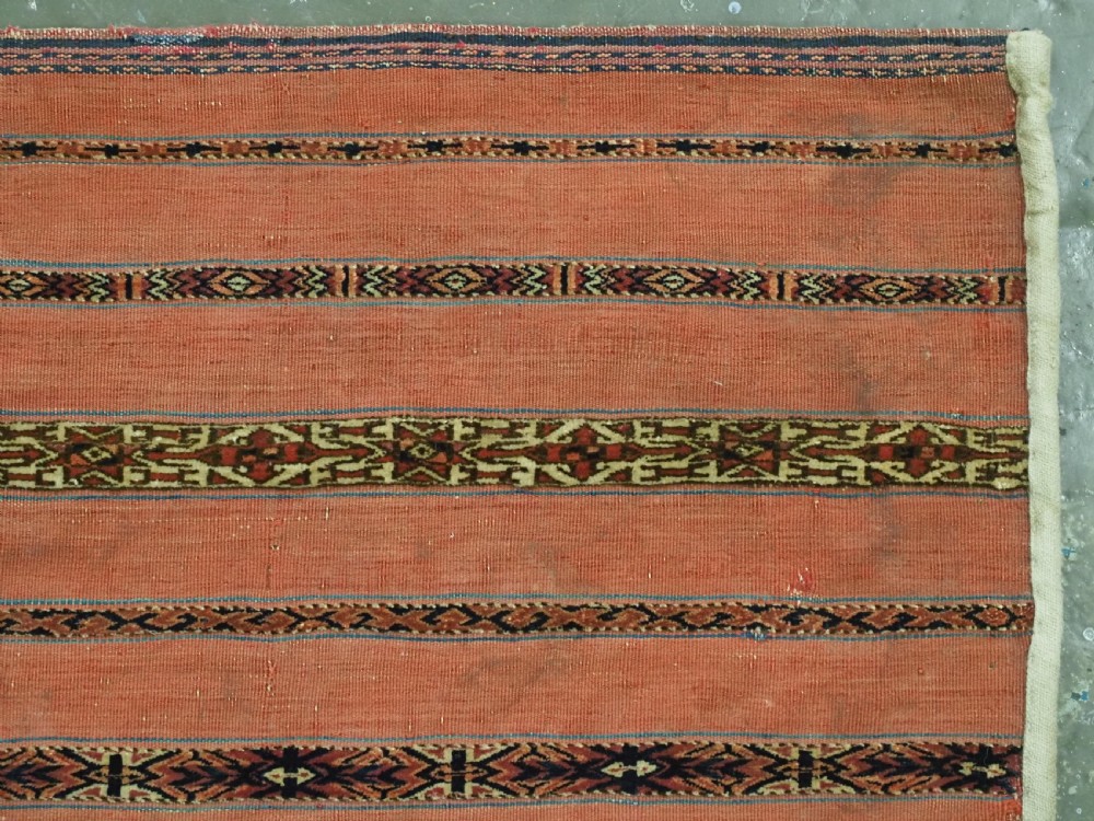 A pair of rectangular antique Turkmen Kizil chuval woven textiles in terracotta red with thin horizontal geometric bands and cream backing edges. View VII