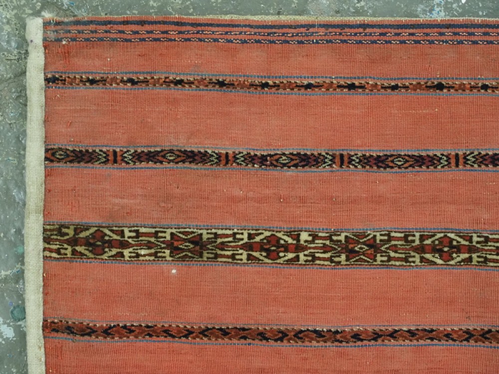 A pair of rectangular antique Turkmen Kizil chuval woven textiles in terracotta red with thin horizontal geometric bands and cream backing edges. View VIII