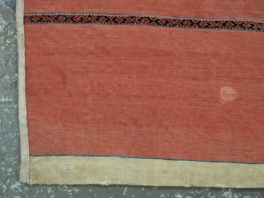 A pair of rectangular antique Turkmen Kizil chuval woven textiles in terracotta red with thin horizontal geometric bands and cream backing edges. View IX