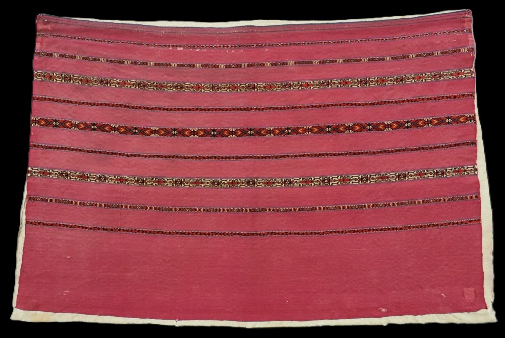 An antique rectangular Tekke Turkmen Kizil chuval woven textile with detailed horizontal geometric bands across a magenta red wool field.